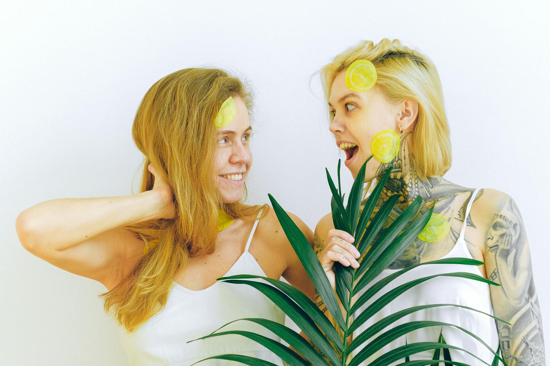 Two people laughing and holding fresh lemons indoors, expressing joy and comfort