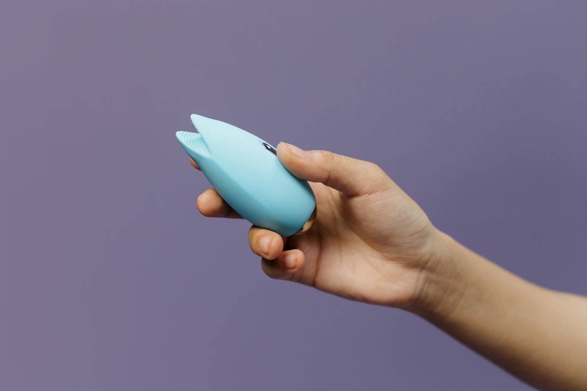 A silicone lemon clitoral vibrator held in hand, showcasing the design of modern suction-based sex toys
